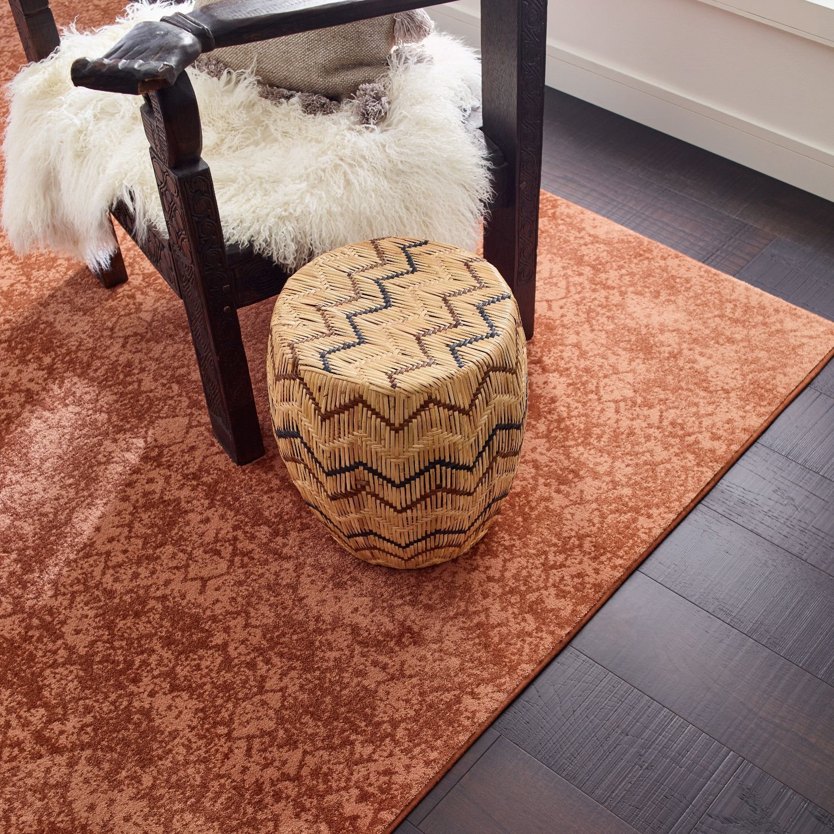 room with dark hardwood flooring and an orange patterned rug from The Carpet Shoppe Inc in Tulare, CA