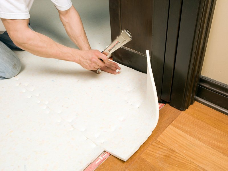 person installing flooring underlayment from The Carpet Shoppe Inc in Tulare, CA