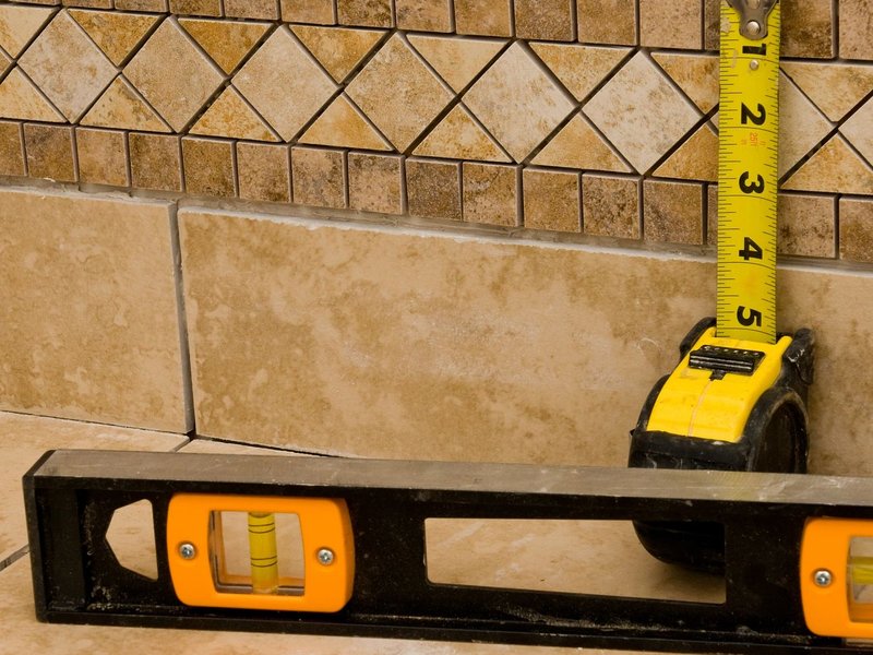 Tape measure and spirit level on tiled floor - Free in-home measurements by The Carpet Shoppe Inc in Tulare, CA