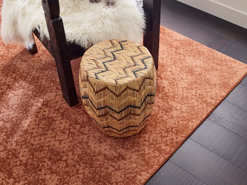 room with dark hardwood flooring and an orange patterned rug from The Carpet Shoppe Inc in Tulare, CA